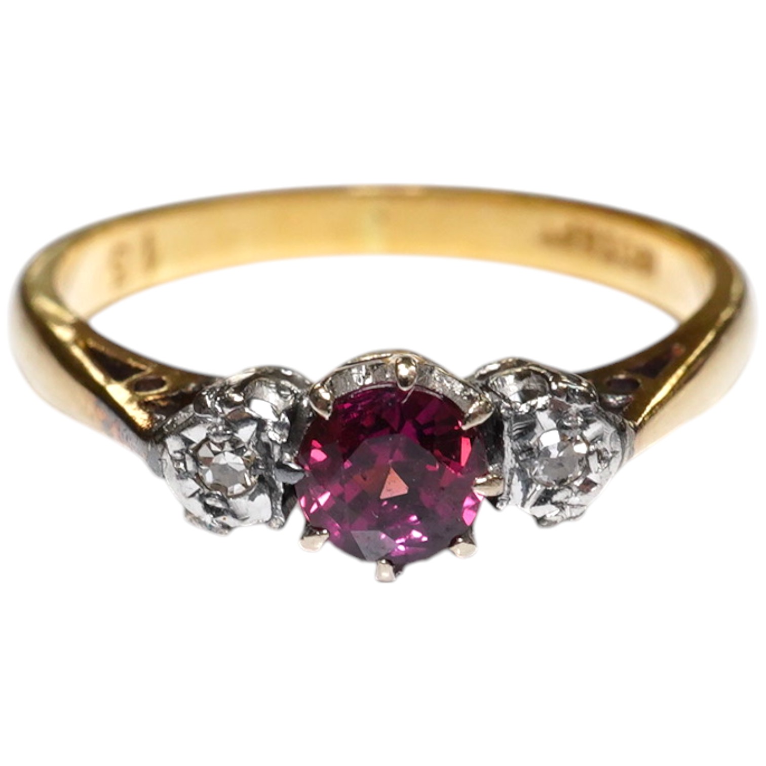 An 18ct and platinum ruby and diamond set three stone ring, size O, gross weight 3.1 grams. Condition - fair